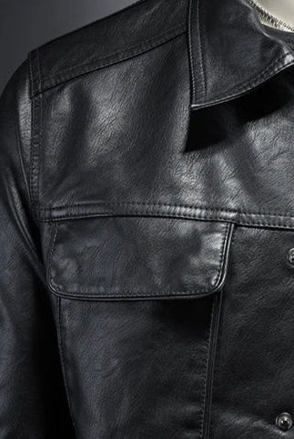 Close-up of a black leather jacket with a dark background