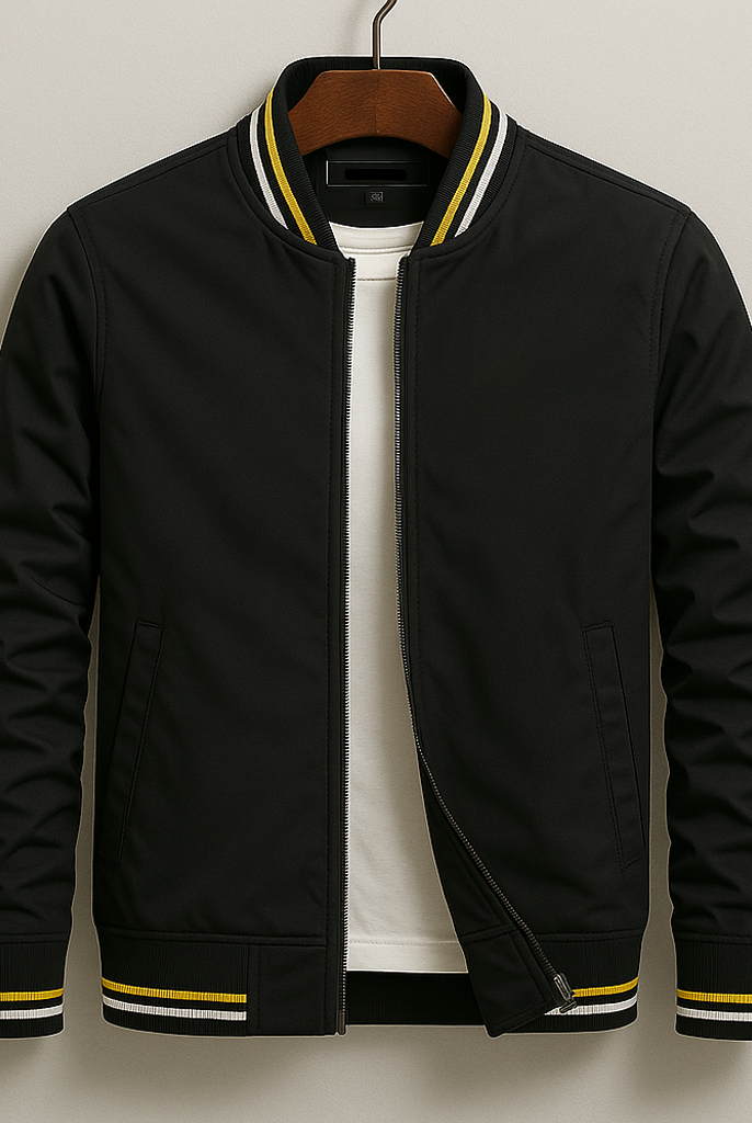 Black bomber jacket with yellow accents on a hanger against a beige background