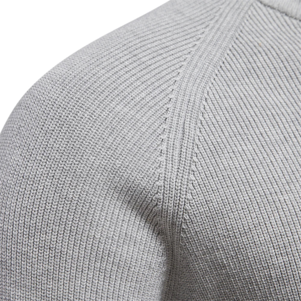 Close-up of a gray sweater sleeve with ribbed texture on a white background