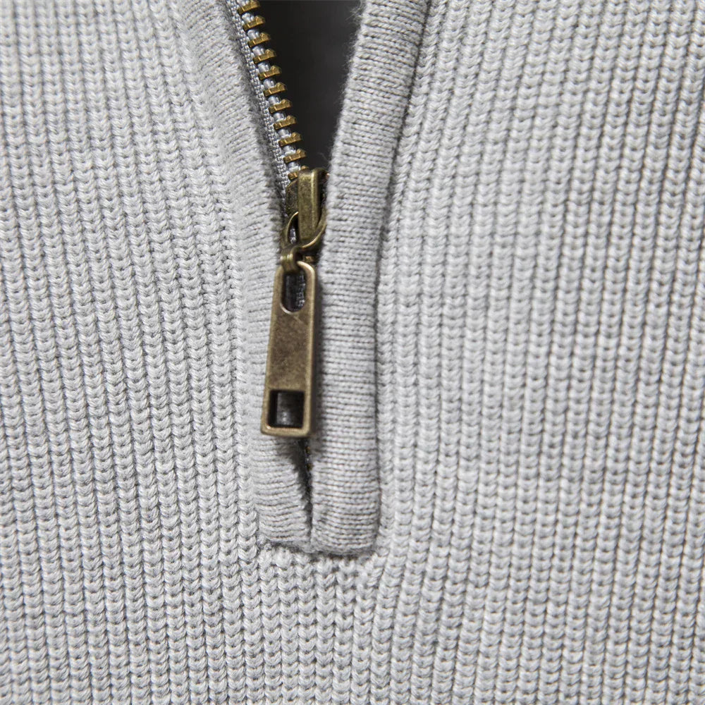 Close-up of a textured gray fabric with a zipper pull.