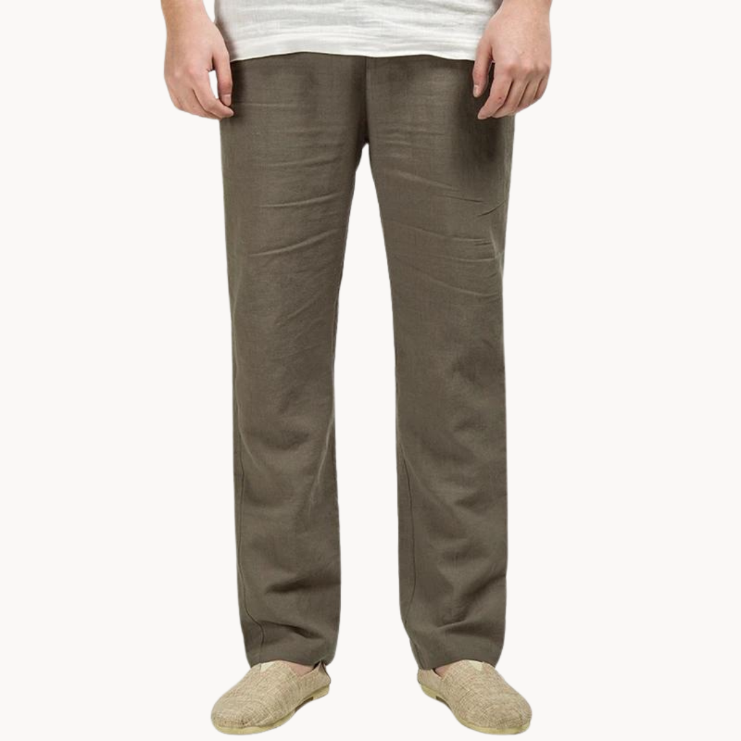 Person wearing brown linen pants on a white background