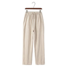Linen beige pants on a hanger against a white background
