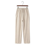Linen beige pants on a hanger against a white background