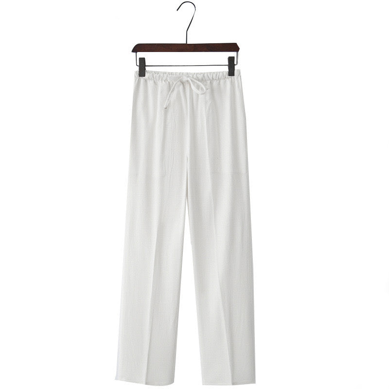 Linen white pants hanging on a wooden hanger against a white background