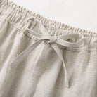 Close-up of beige linen pants with an elastic waistband and tie.