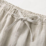 Close-up of beige linen pants with an elastic waistband and tie.