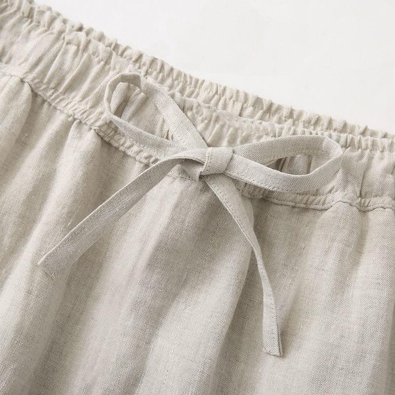 Close-up of beige linen pants with an elastic waistband and tie.