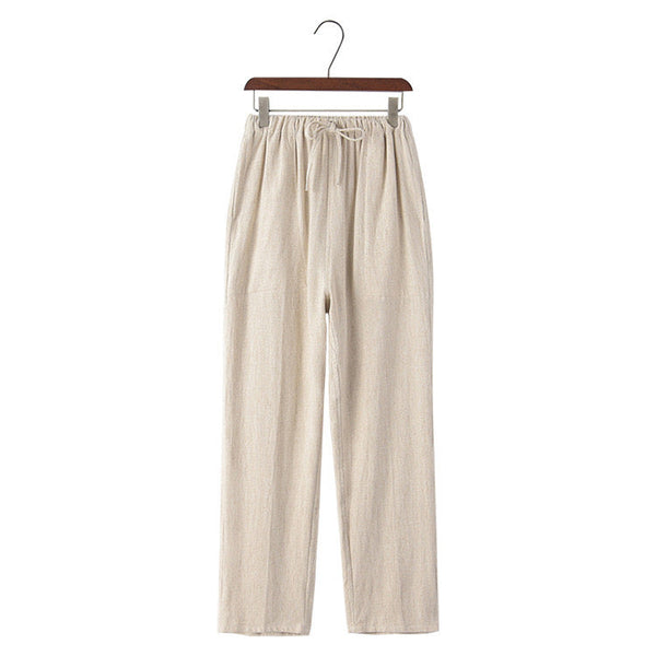 Linen beige pants on a hanger against a white background