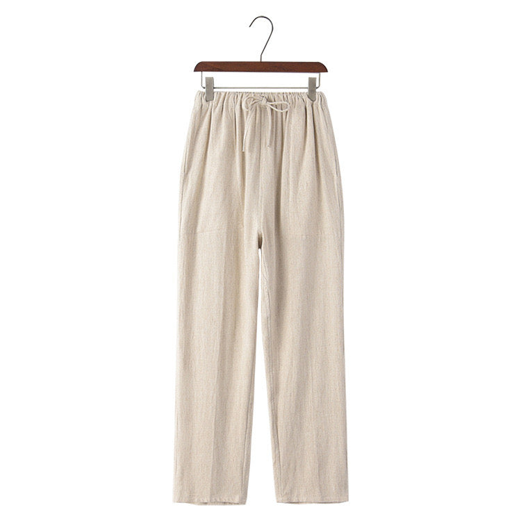 Linen beige pants on a hanger against a white background