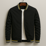Black bomber jacket with yellow accents on a hanger against a beige background