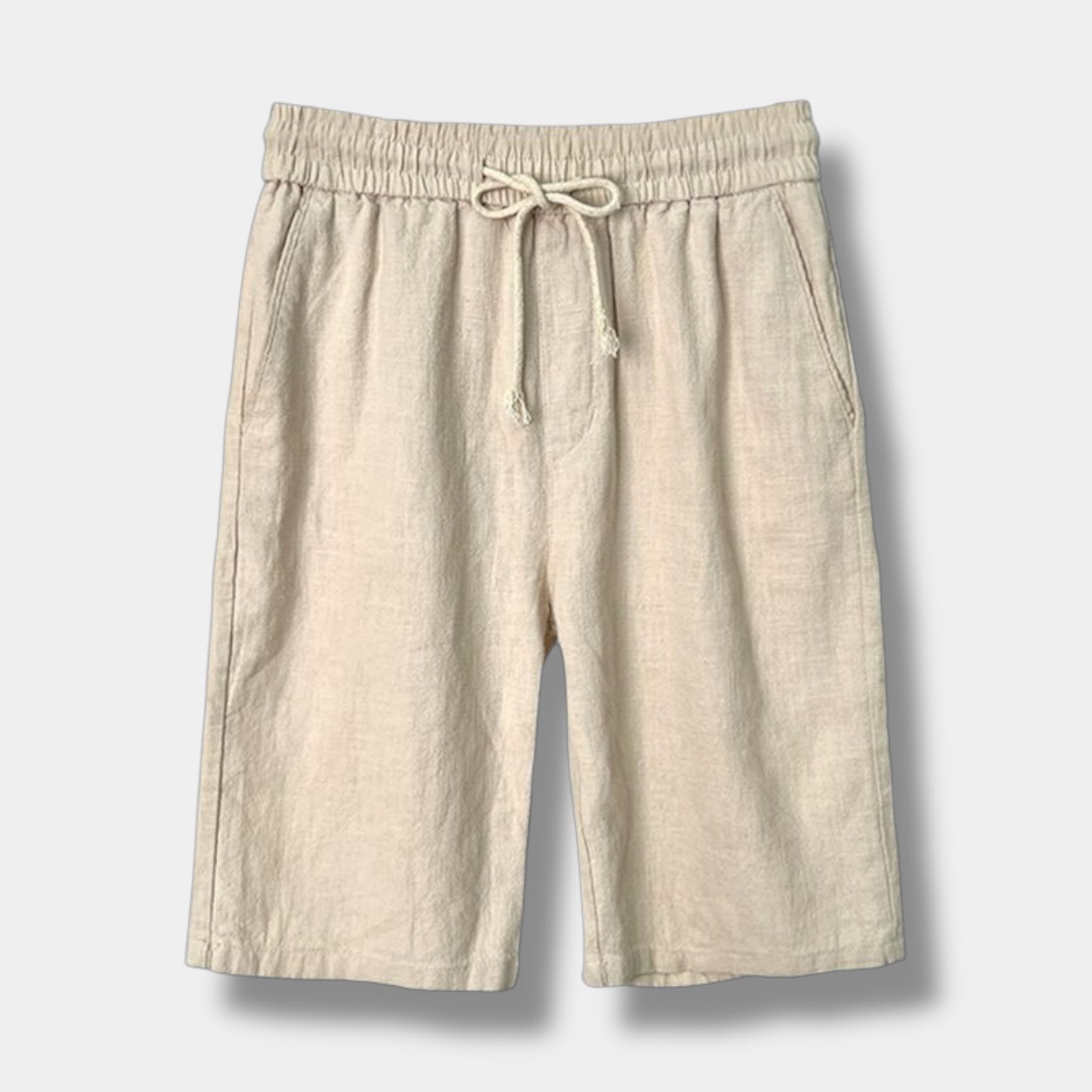 Beige linen shorts with a drawstring on a light gray background