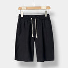 Black linen shorts with a drawstring on a white background