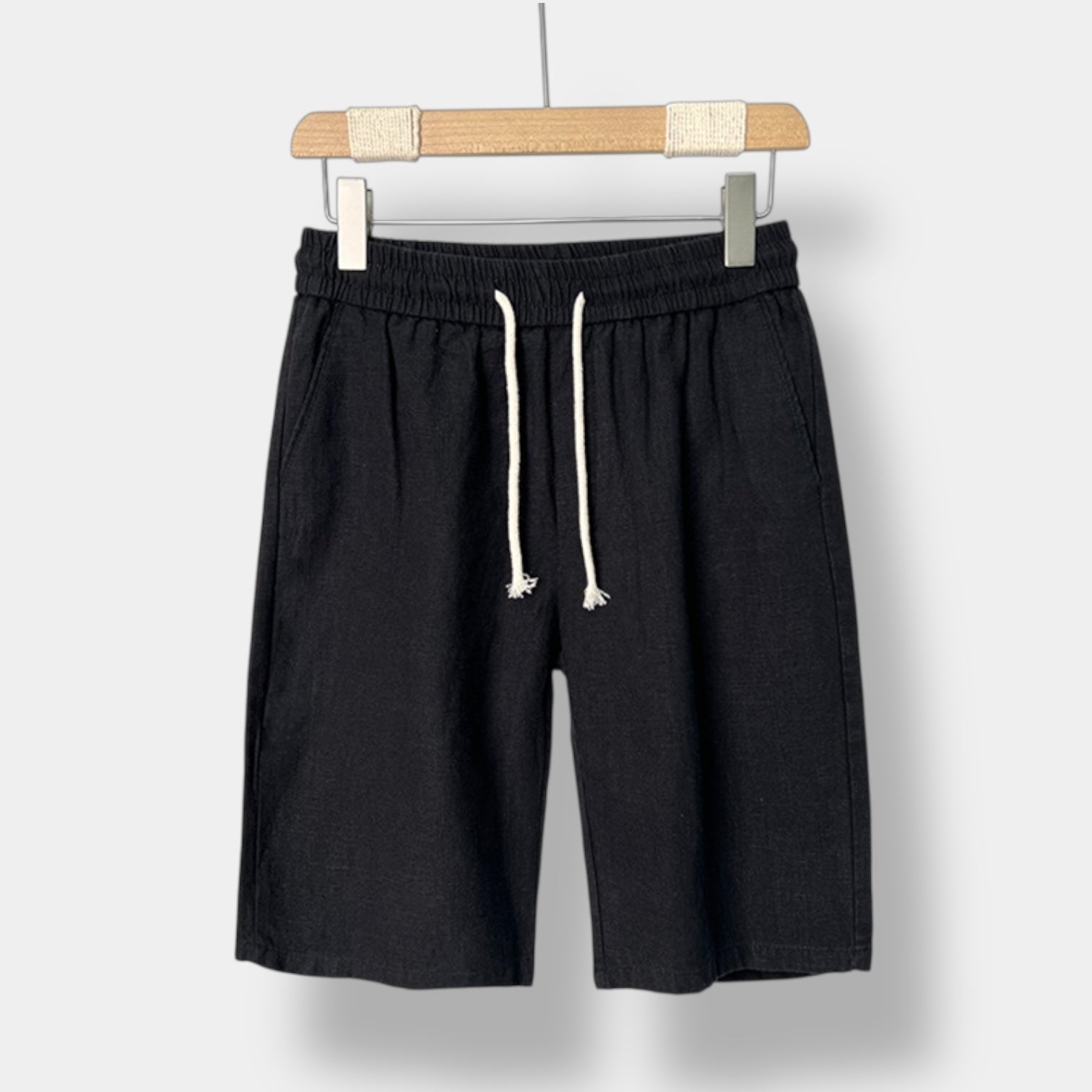 Black linen shorts with a drawstring on a white background