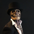 Homme squelette en costume noir et chapeau haut de forme, fond sombre. Look Halloween, déguisement effrayant, ambiance macabre.
