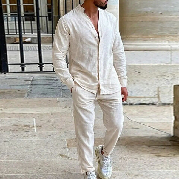Man wearing a beige linen outfit standing in front of a building.