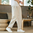 Person wearing beige pants and white sneakers in a cozy indoor setting