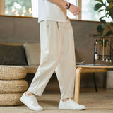 Person wearing beige pants and white sneakers in a cozy indoor setting