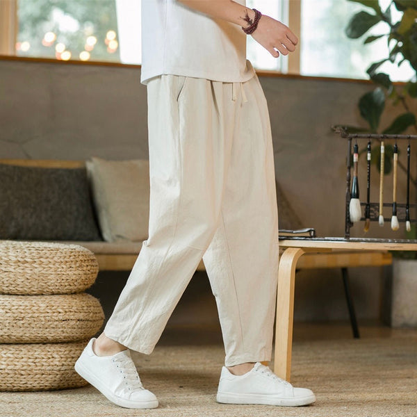 Person wearing beige pants and white sneakers in a cozy indoor setting